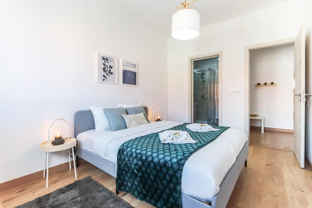 een slaapkamer met een bed met een groene en witte deken bij Vita Portucale ! Almada Balcony in Almada