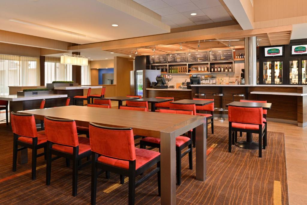 a restaurant with a large table and chairs at Courtyard by Marriott Dallas Northwest in Dallas