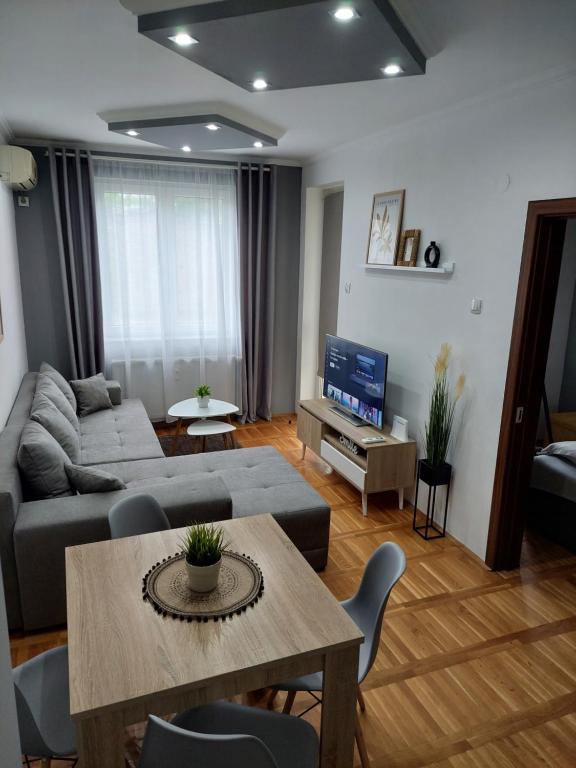 ein Wohnzimmer mit Sofa und Tisch in der Unterkunft Smiley - Subotica Centar in Subotica