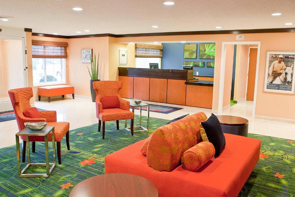 un soggiorno con divano rosso e sedie di Fairfield Inn & Suites by Marriott Memphis East Galleria a Memphis