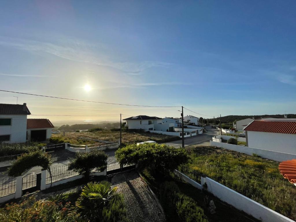 uma vista para uma cidade com o sol no céu em NO CEU - A fully private flat in the sky with Ocean view em Atouguia da Baleia