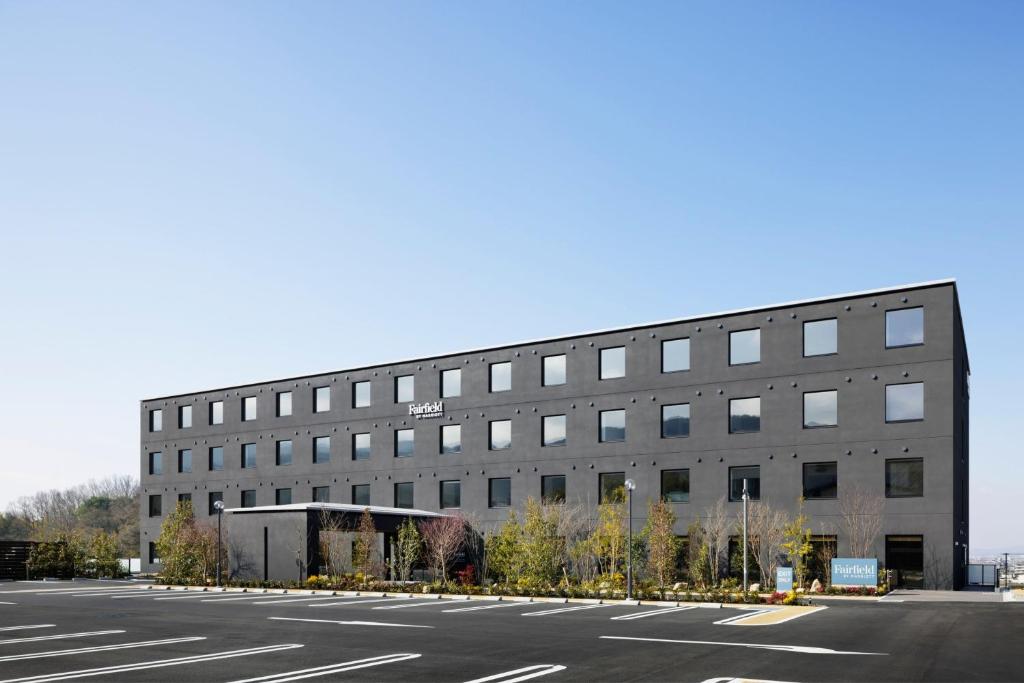 a large building with a parking lot in front of it at Fairfield by Marriott Nara Tenri Yamanobenomichi in Tenri