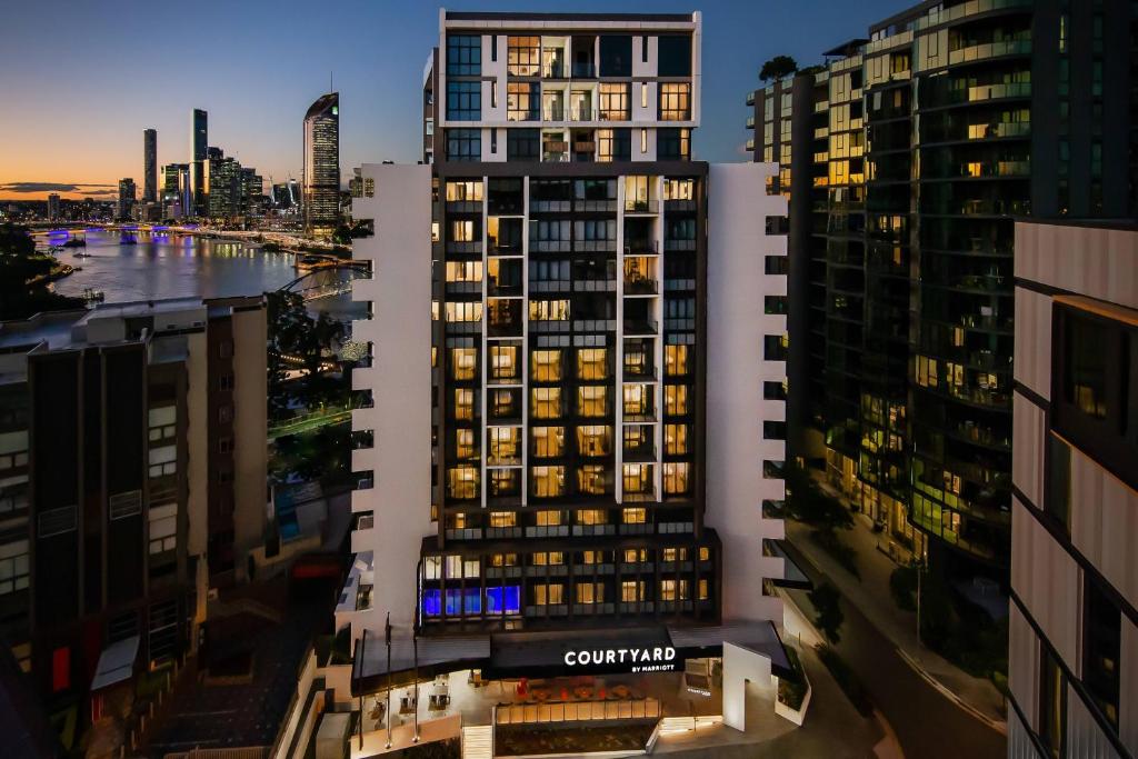 Courtyard by Marriott Brisbane South Bank في بريزبين: منظر على أفق المدينة في الليل