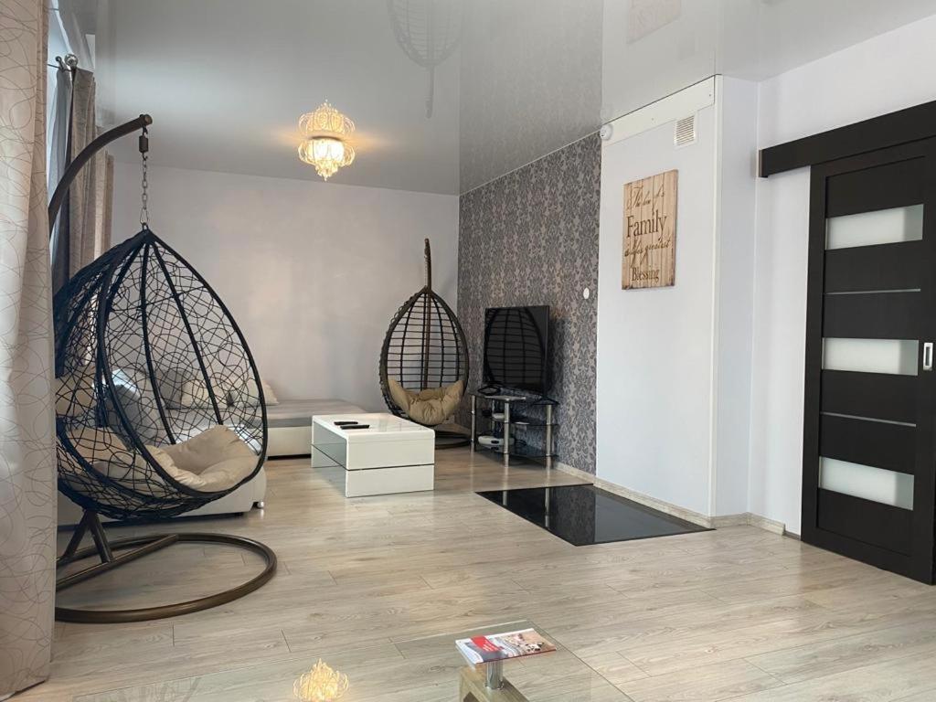 a living room with two swinging chairs in a room at Svetes house - Garden & BBQ & Parking in Liepāja