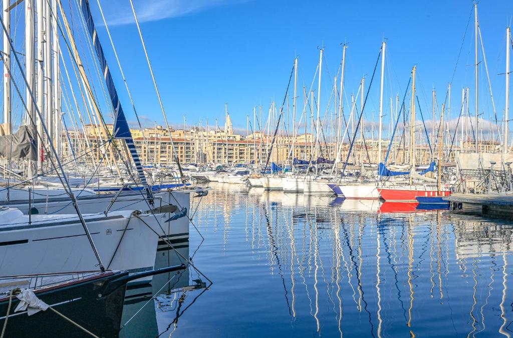 um grupo de barcos ancorados num porto com uma cidade em Sur le port de Marseille ~ Hypercentre ~ La Criée em Marselha