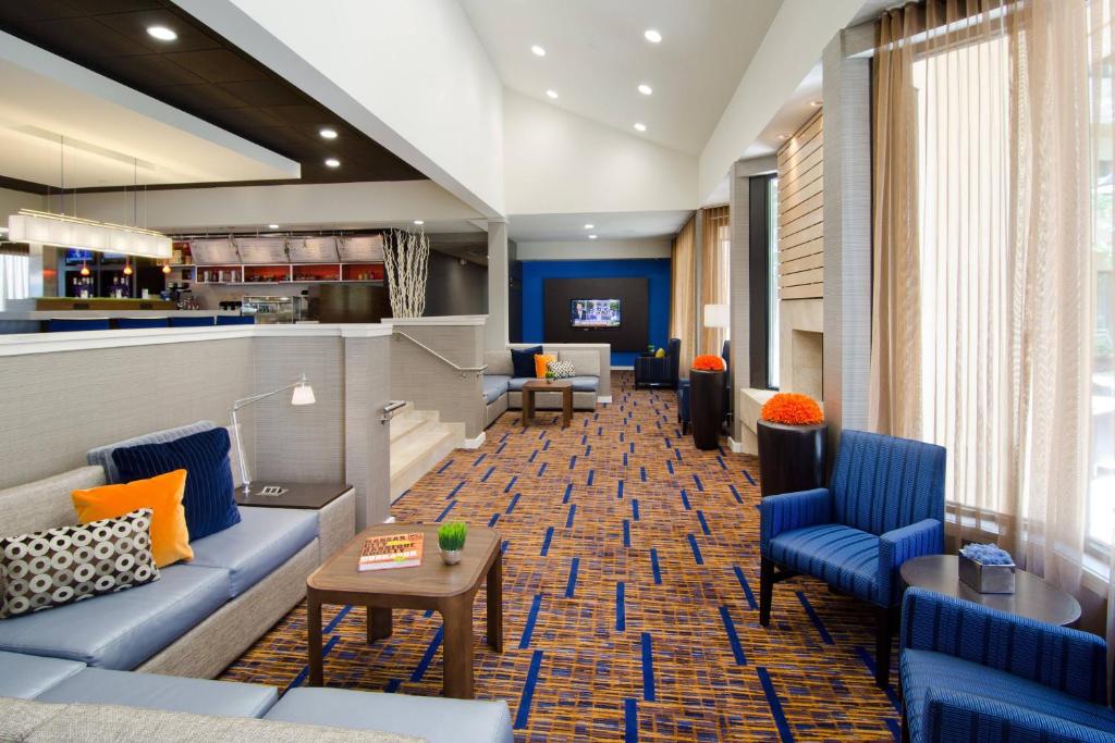a lobby with blue couches and a bar at Courtyard Kansas City Overland Park/Metcalf, South of College Boulevard in Overland Park