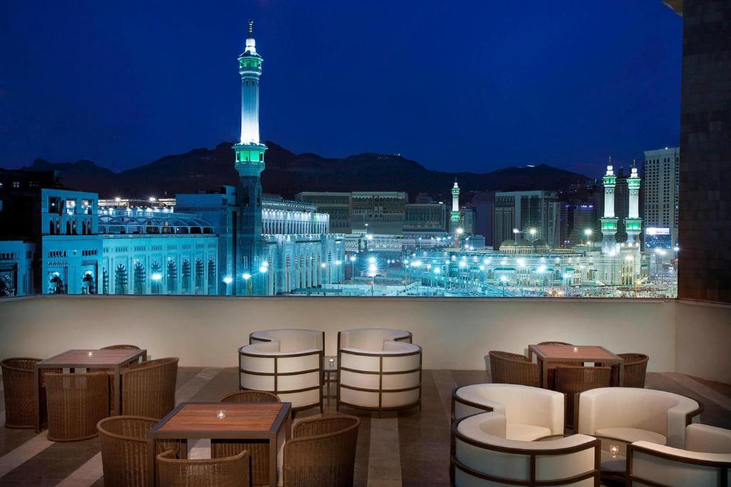 een restaurant met uitzicht op de stad 's nachts bij Jabal Omar Marriott Hotel Makkah in Mekka