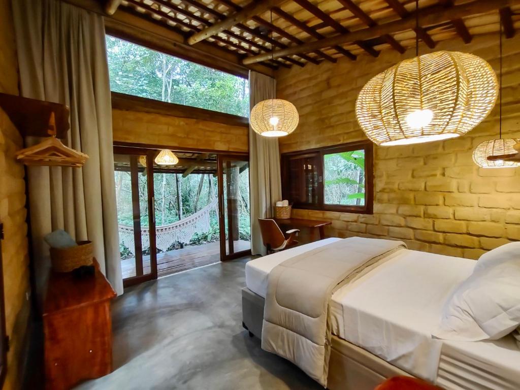 1 dormitorio con 1 cama y algunas ventanas en Chalés Vila Floresta, en Alto Paraíso de Goiás