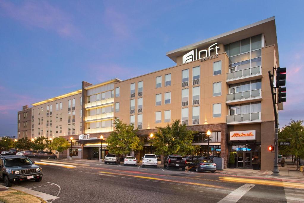 a building on a street with cars parked in front of it at Aloft Birmingham Soho Square in Homewood