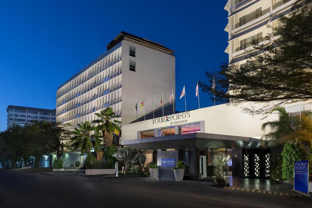 um edifício com bandeiras na lateral em Four Points by Sheraton Dar es Salaam New Africa em Dar es Salaam