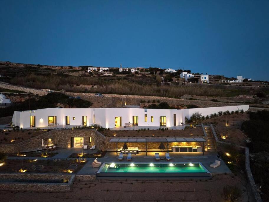 una casa grande con piscina por la noche en Olithos Villas, en Krotiri