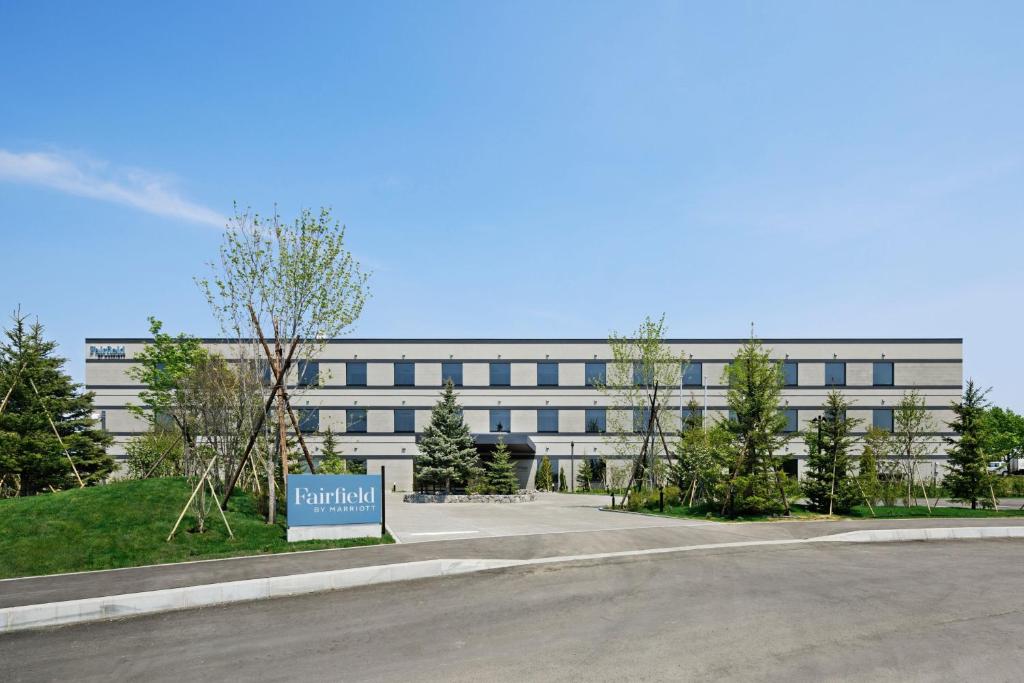 a large white building with a sign in front of it at Fairfield by Marriott Hokkaido Naganuma in Naganuma