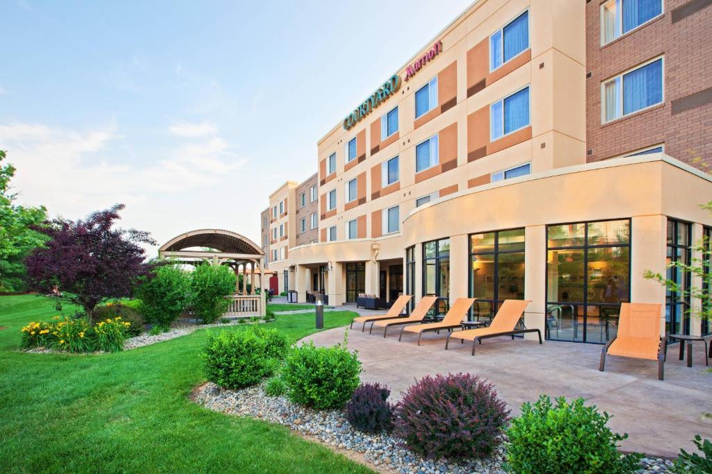 ariott hotel with chairs outside of a building at Courtyard Louisville Northeast in Louisville