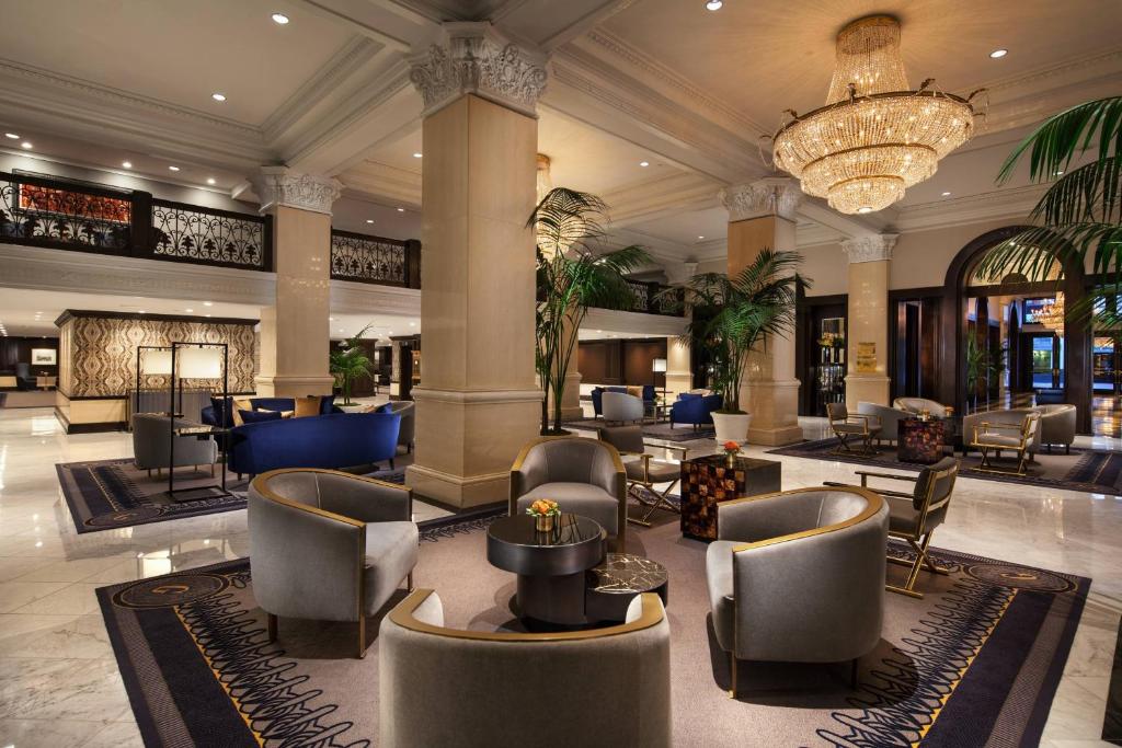 a lobby with chairs and tables and a chandelier at The US Grant, a Luxury Collection Hotel, San Diego in San Diego