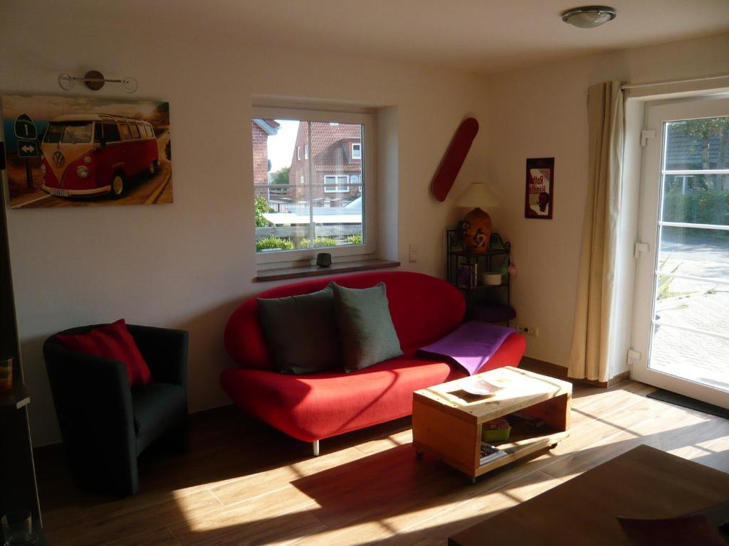 - un salon avec un canapé rouge et une fenêtre dans l'établissement Aloha 2, à Neue Tiefe Fehmarn