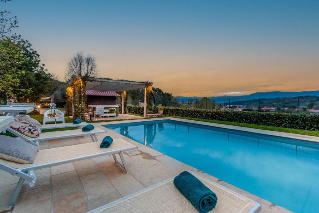 - une piscine avec une table et des chaises à côté dans l'établissement Villa Catia Farmhouse, Three Luxury Bedrooms, a Jacuzzi Pool and a Dream-Like Getaway Experience, à Capannori