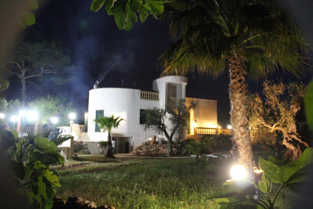 una casa di notte con una palma e luci di B&B Villa Gallipoli a Gallipoli