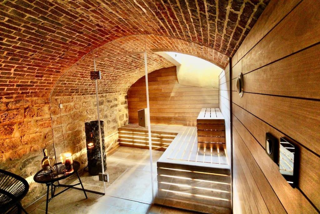 a room with a fireplace in a brick wall at Le Spa Beauvoisine - Jacuzzi Sauna Rouen centre Free parking in Rouen