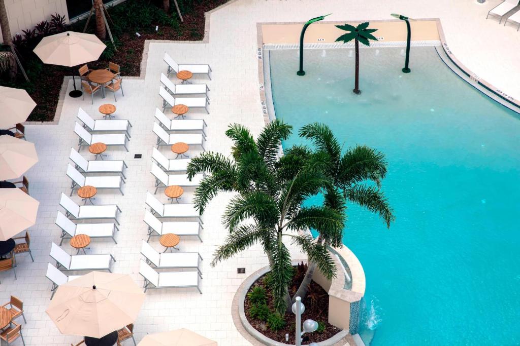 an overhead view of a pool with umbrellas and a palm tree at TownePlace Suites by Marriott Orlando Theme Parks/Lake Buena Vista in Orlando