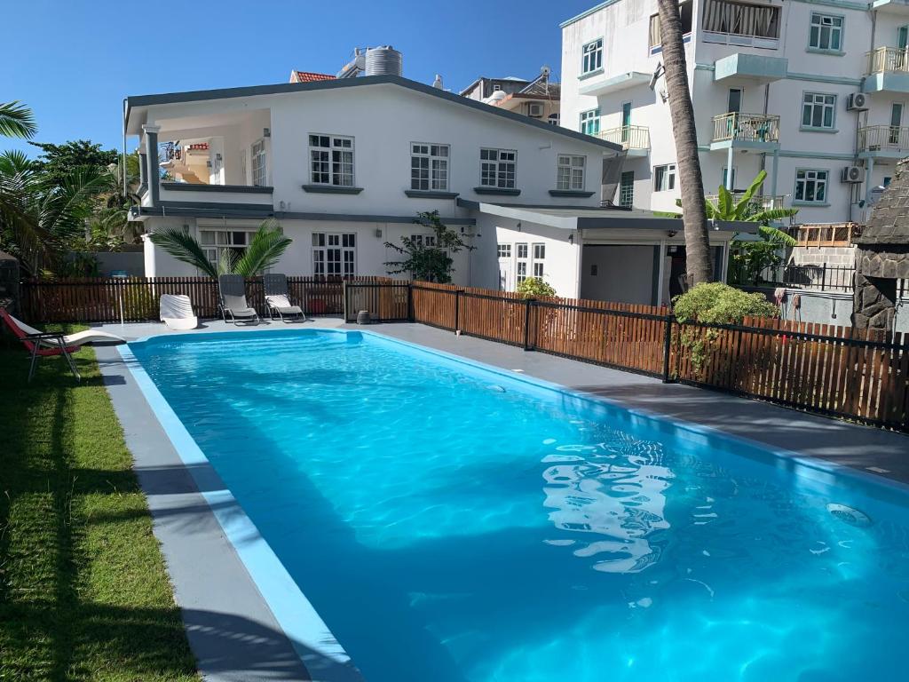 a swimming pool in front of a house at White Castle villa in Pereybere