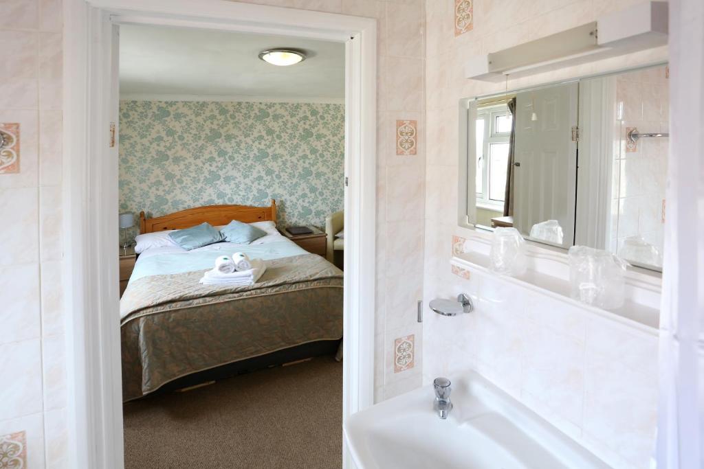 una camera da letto con un letto, un lavandino e una vasca di Dorset Hotel, Isle of Wight a Ryde