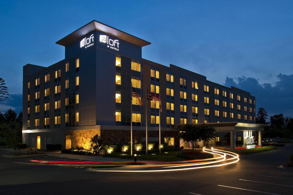 a hotel building with a sign on top of it at Aloft Charlotte Ballantyne in Charlotte