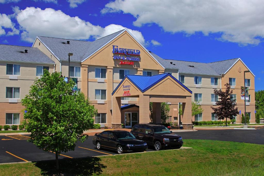 a hotel with two cars parked in a parking lot at Fairfield Inn & Suites Traverse City in Traverse City