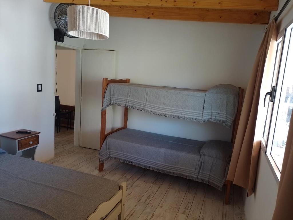 una habitación con sofá y cama en una habitación en Hospedaje La Calma, en San Miguel del Monte