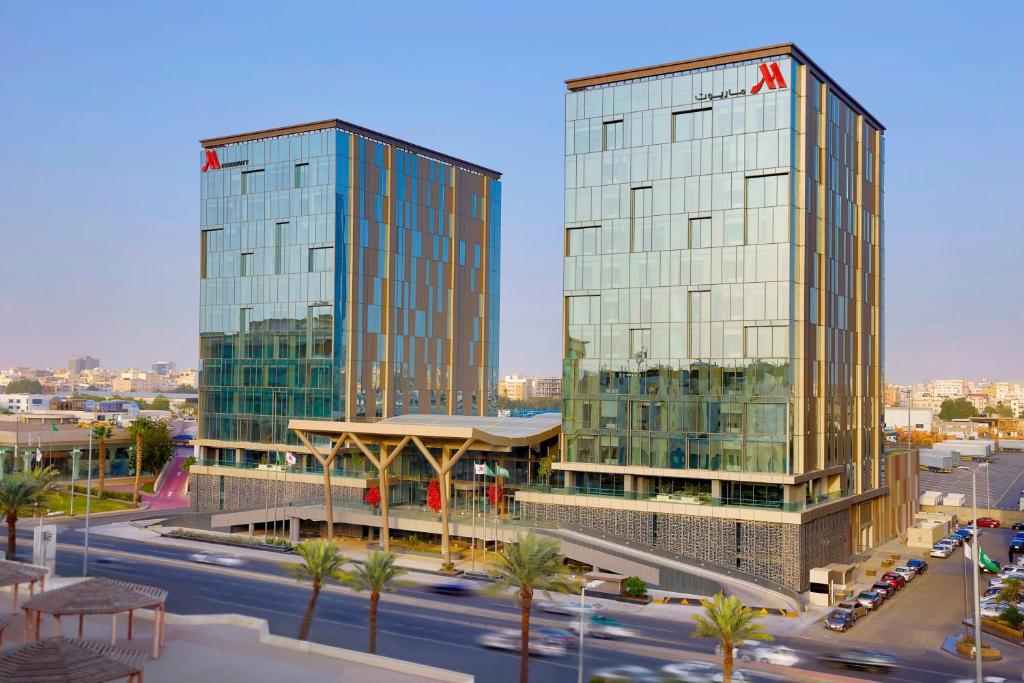 two tall glass buildings in a city with a street at Jeddah Marriott Hotel Madinah Road in Jeddah
