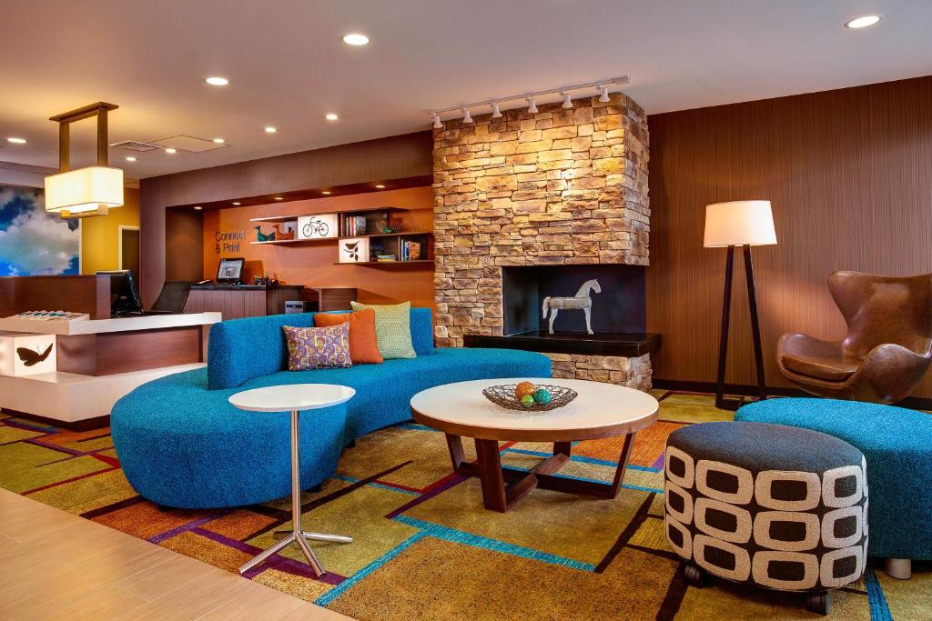 een woonkamer met blauwe meubels en een open haard bij Fairfield Inn & Suites by Marriott Lincoln Southeast in Lincoln