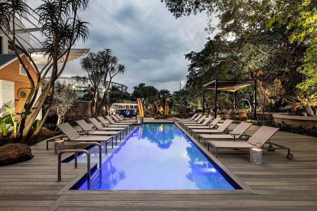 a swimming pool with lounge chairs and a playground at Protea Hotel Fire & Ice! by Marriott Durban Umhlanga Ridge in Durban