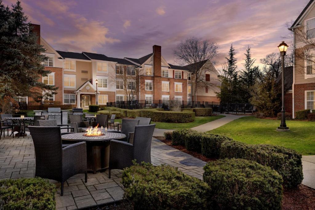 a courtyard with a table and chairs and a building at Residence Inn Saddle River in Saddle River