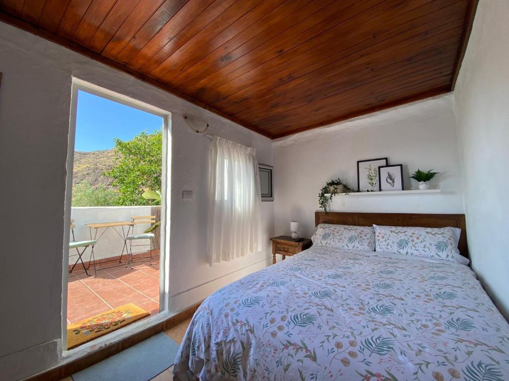 - une chambre avec un lit et une grande fenêtre dans l'établissement B&B and Apartments El Charco Azul, à El Risco