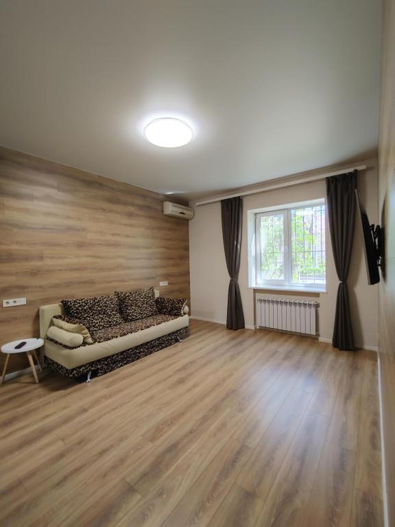 a living room with a couch and a wooden floor at Квартира в районе 5-ой фонтана in Odesa