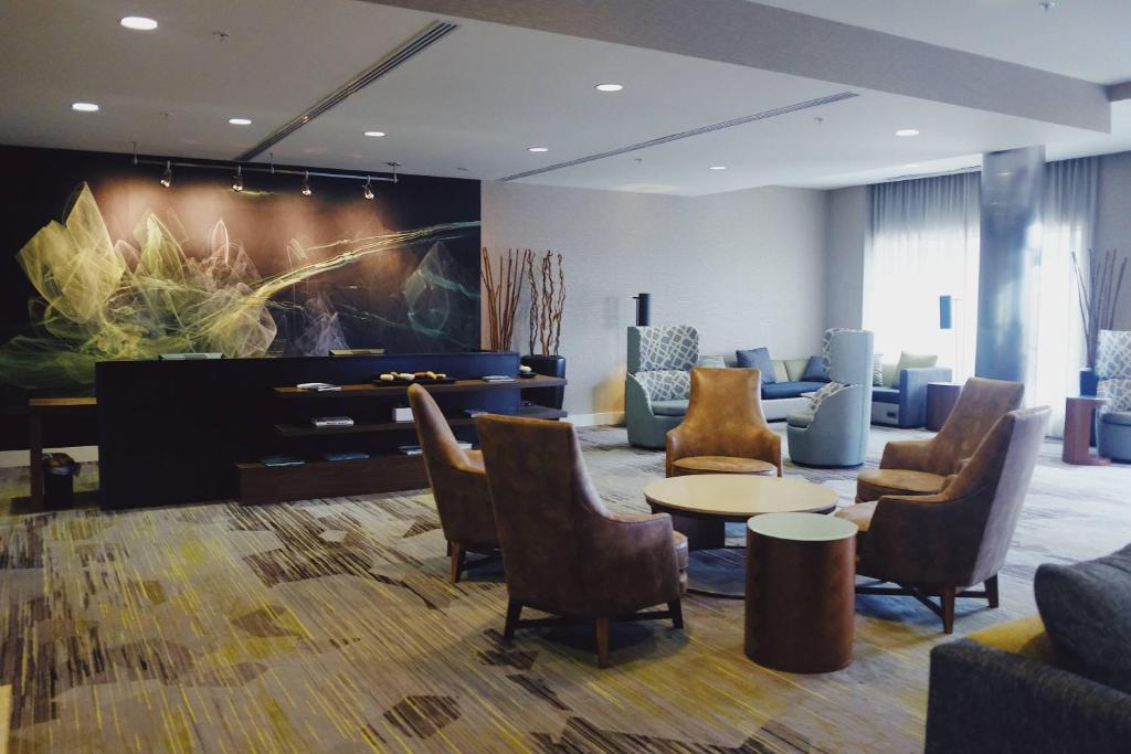 a lobby with a waiting area with chairs and a table at Courtyard by Marriott Owensboro in Owensboro