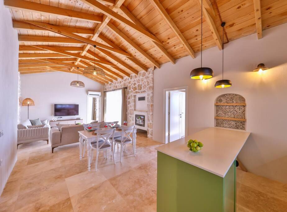 een keuken en een woonkamer met een tafel en stoelen bij Villa No11 Kaş Üzümlü Köyü in Kas