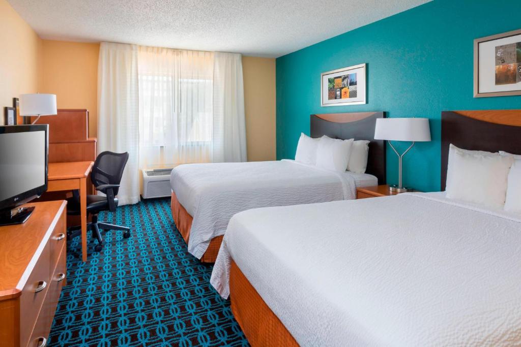 a hotel room with two beds and a flat screen tv at Fairfield Inn & Suites Temple Belton in Temple