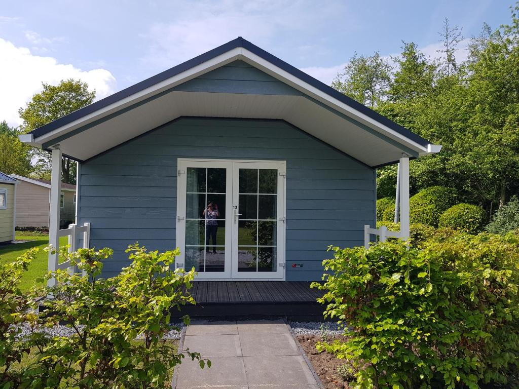 een blauw tiny house met een veranda bij De Bijsselse Enk, Noors chalet 13 in Nunspeet