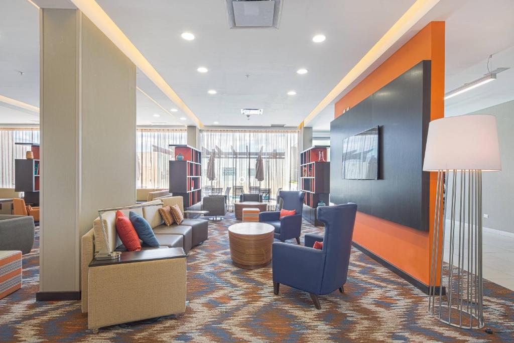 a lobby with couches and chairs and a lamp at Courtyard by Marriott Saltillo in Saltillo
