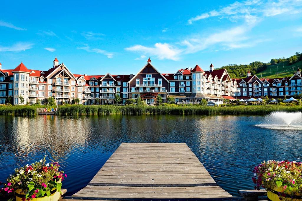 a dock in the middle of a lake with buildings at The Westin Trillium House, Blue Mountain in Blue Mountains