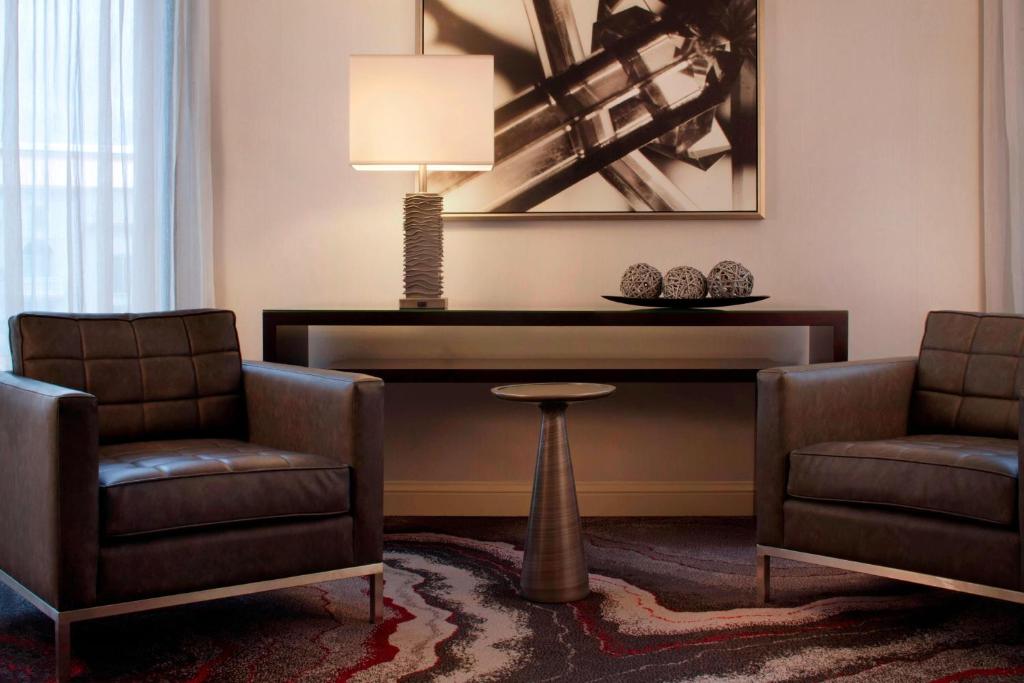 a living room with two chairs and a table at Denver Airport Marriott at Gateway Park in Aurora