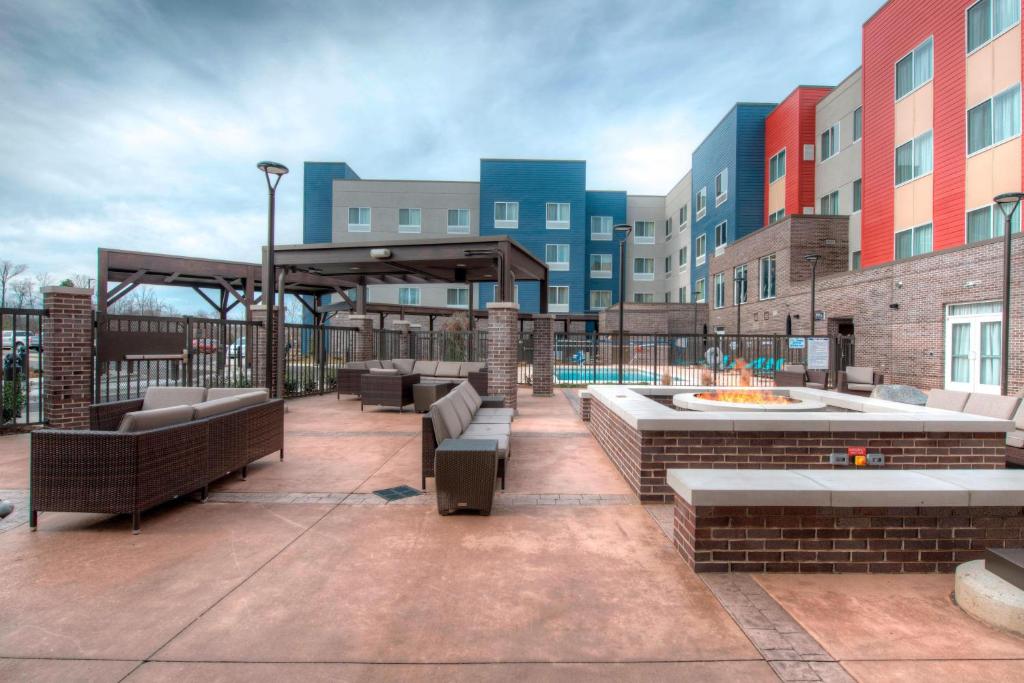 eine Terrasse mit Bänken und einer Feuerstelle auf einem Gebäude in der Unterkunft Fairfield Inn & Suites by Marriott Charlotte Airport in Charlotte