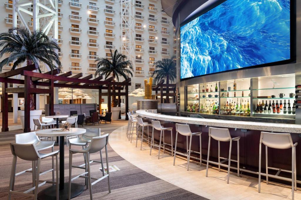 a bar with chairs and a large screen in a hotel lobby at Renaissance Orlando at SeaWorld® in Orlando