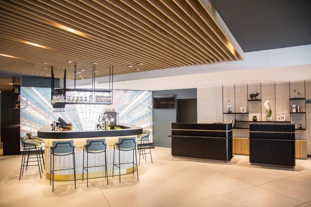a kitchen with a bar with stools at Courtyard by Marriott Paris Arcueil in Arcueil