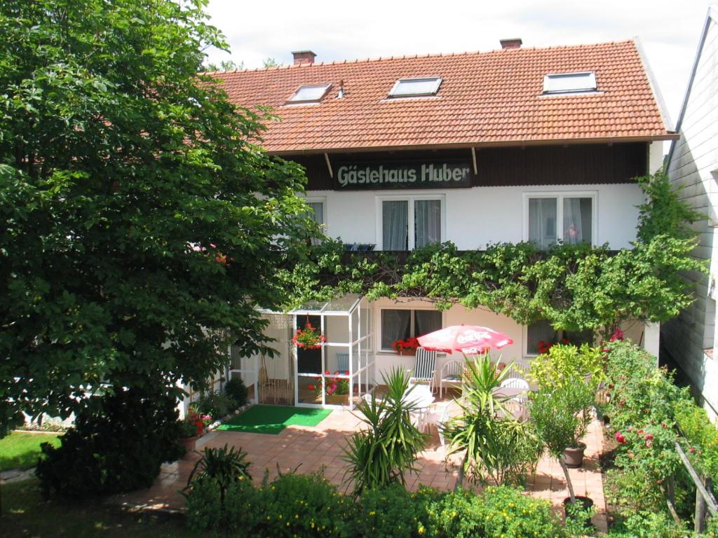 una casa con un paraguas delante en Gästehaus Huber - traditional Sixties Hostel, en Feichten