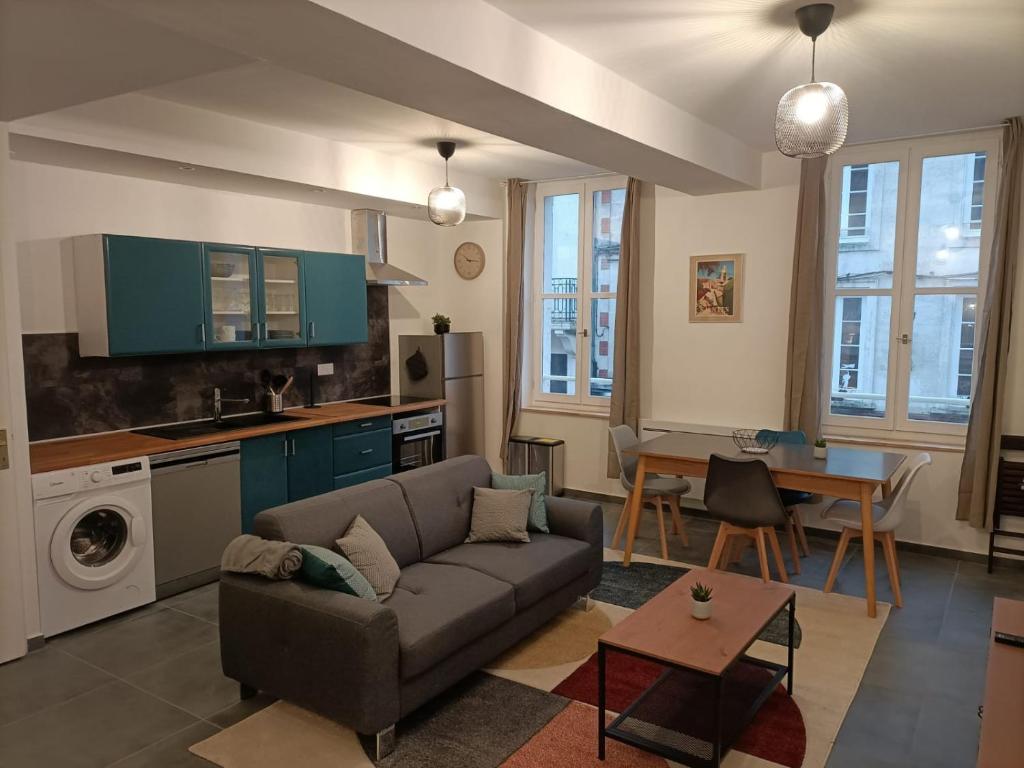 een woonkamer met een bank en een tafel bij Appartement Saintes, centre historique in Saintes