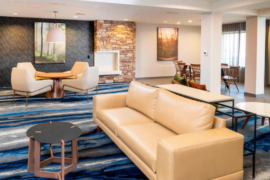 Fairfield Inn & Suites Bend Downtown في بيند: غرفة معيشة مع أريكة وطاولات
