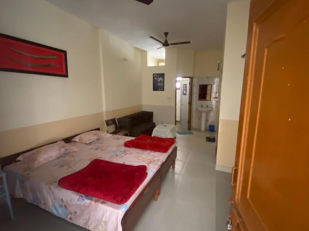 a bedroom with a bed with red blankets on it at Negi Lodge Chandigarh in Chandīgarh