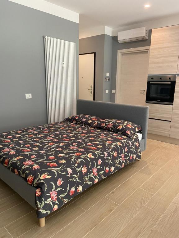 una camera da letto con un letto con copriletto floreale di Casa di Laura mono e bilo di fronte Ospedale San Raffaele a Segrate