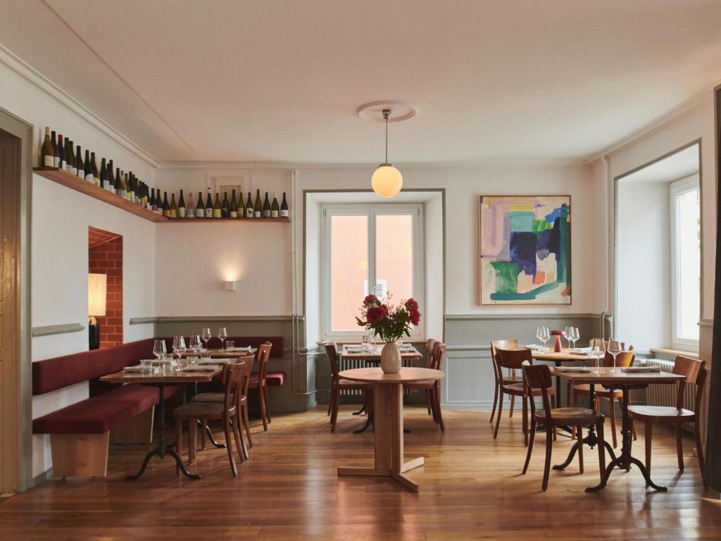 a dining room with tables and chairs and a window at Auberge du Mouton in Porrentruy